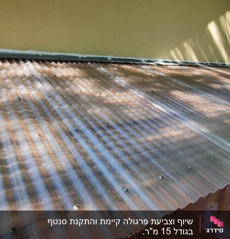 גג מתכת גלי עם ברגים על מבנה עץ